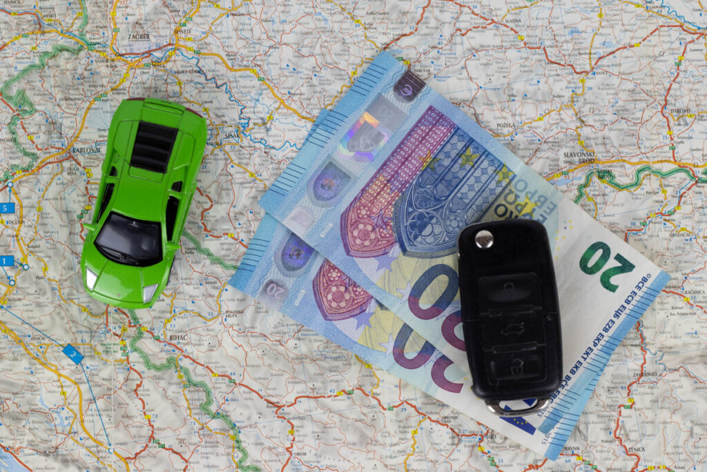 money, a key, and a car toy over a map